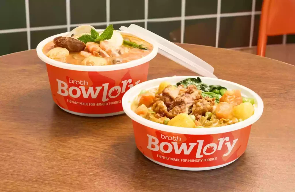 Leak proof soup container design with vibrant branding, holding tom yum and curry meals for takeout food service